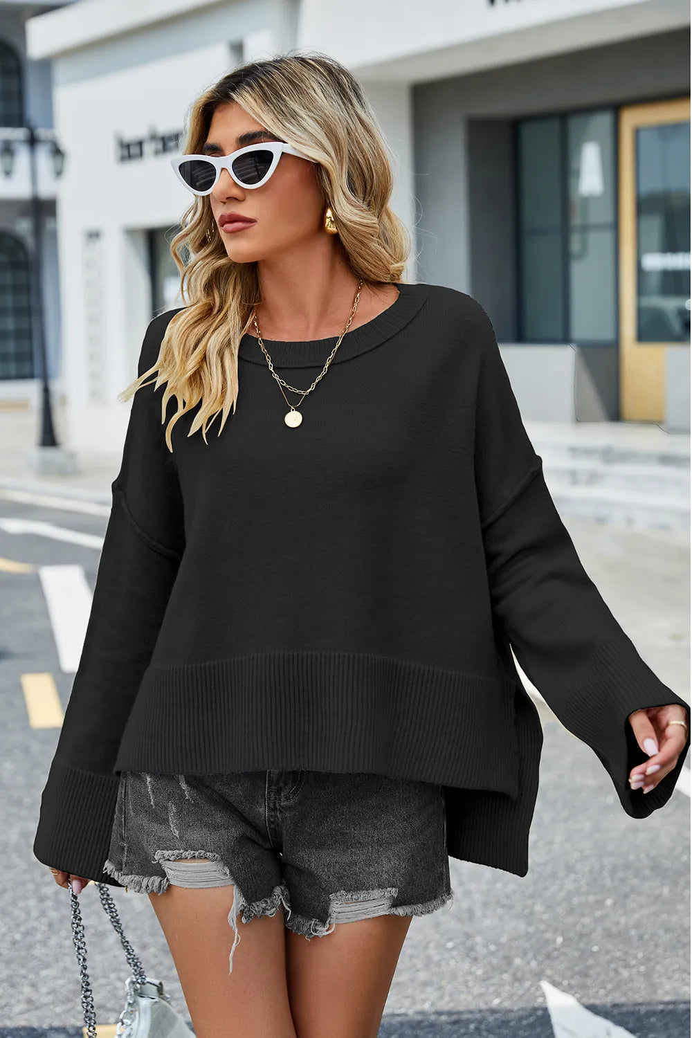 Black round-neck long-sleeve sweater with ribbed bottom; high-low side slit hem