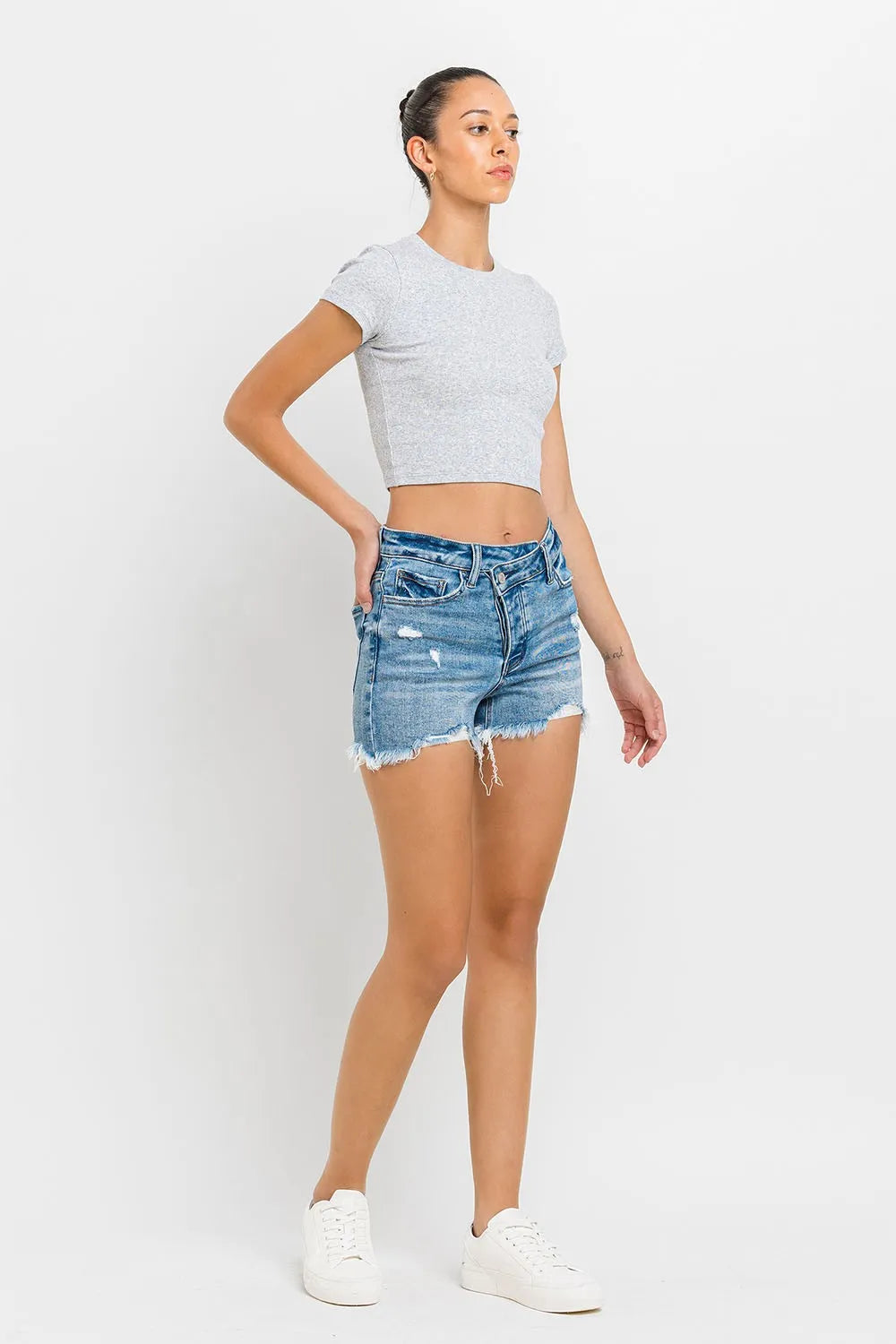 Medium-wash raw-hem denim shorts with distressed details and frayed edges