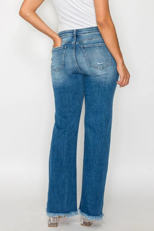 Back view of medium-wash straight jeans with distressed pockets and raw frayed hem