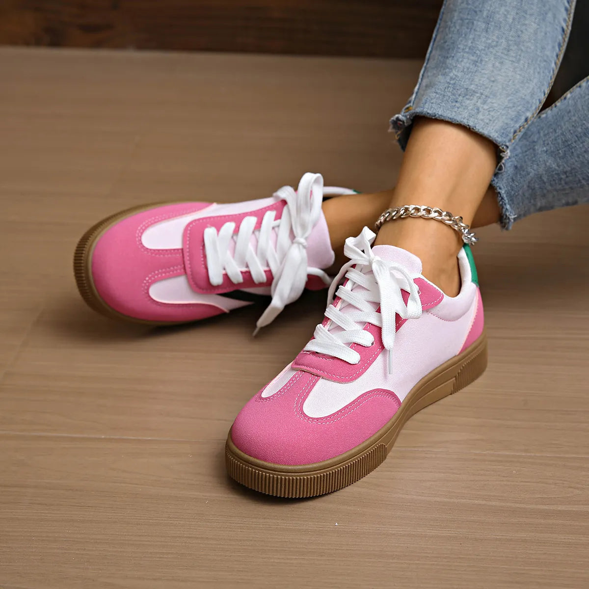 Pink and white lace-up sneakers with tan sole and green heel tab