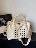 Ivory eyelet embellished crossbody travel bag with top handles and perforated front pocket