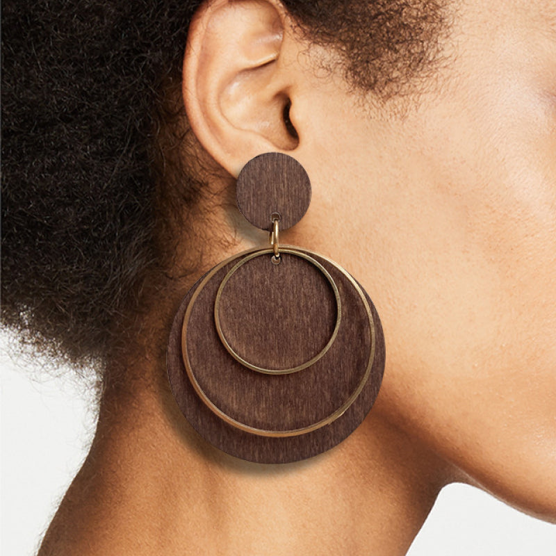Geometric drop earrings on model: brown disc with gold-tone circular layered rings