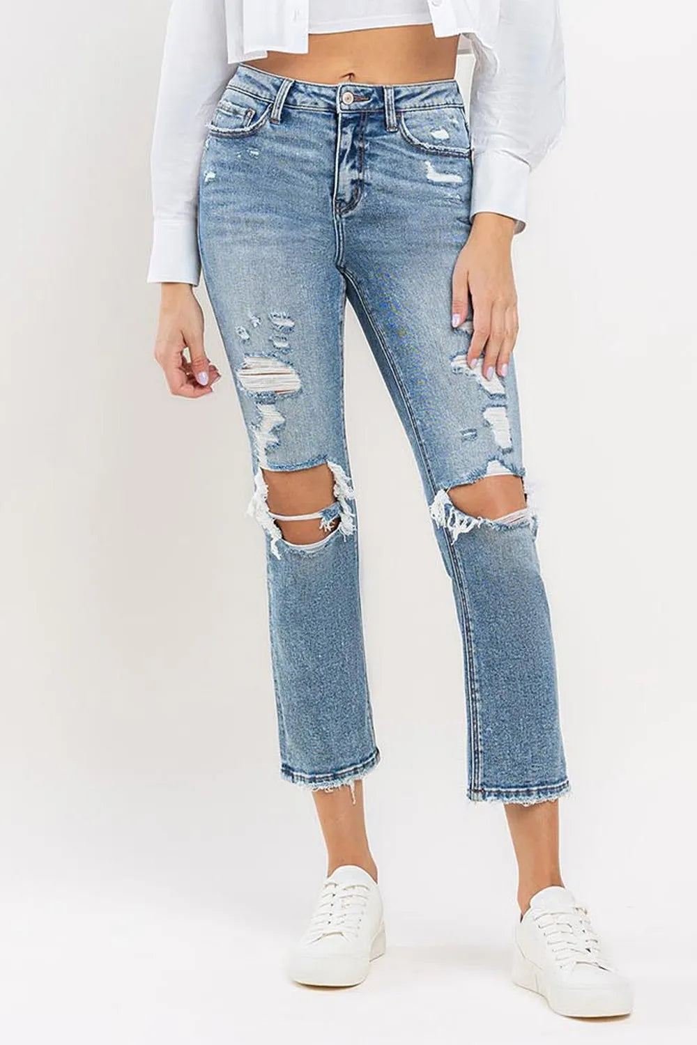 Medium wash high-rise slim straight jeans with knee rips and frayed cropped hem