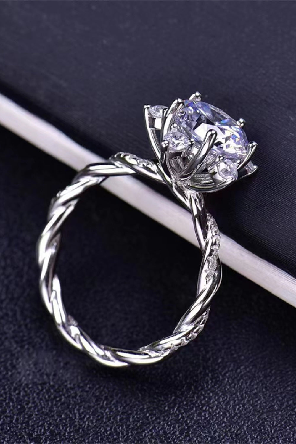 Silver moissanite twisted band with raised oval-style cluster and small round stones