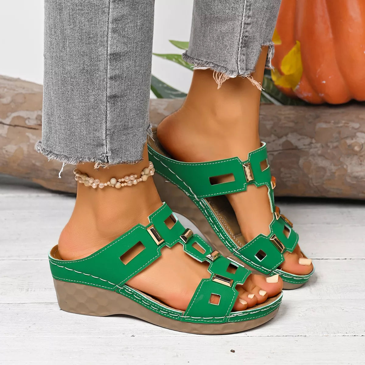 Green open-toe wedge sandal with wide straps, square cutouts, and buckle closures.
