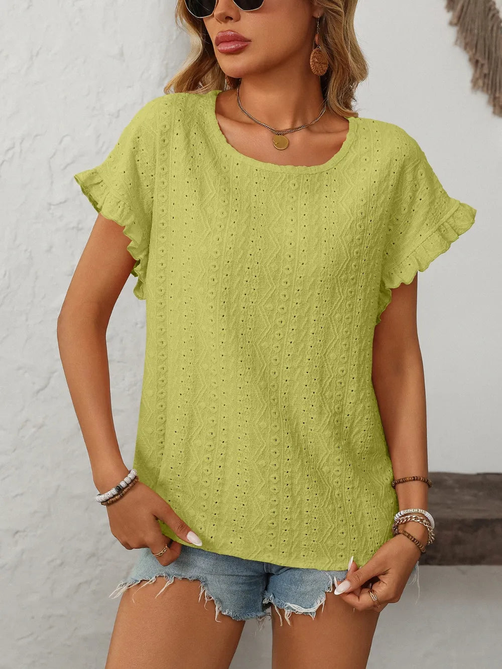 Lime green eyelet round-neck short-sleeve top with flutter sleeves and small dot pattern.