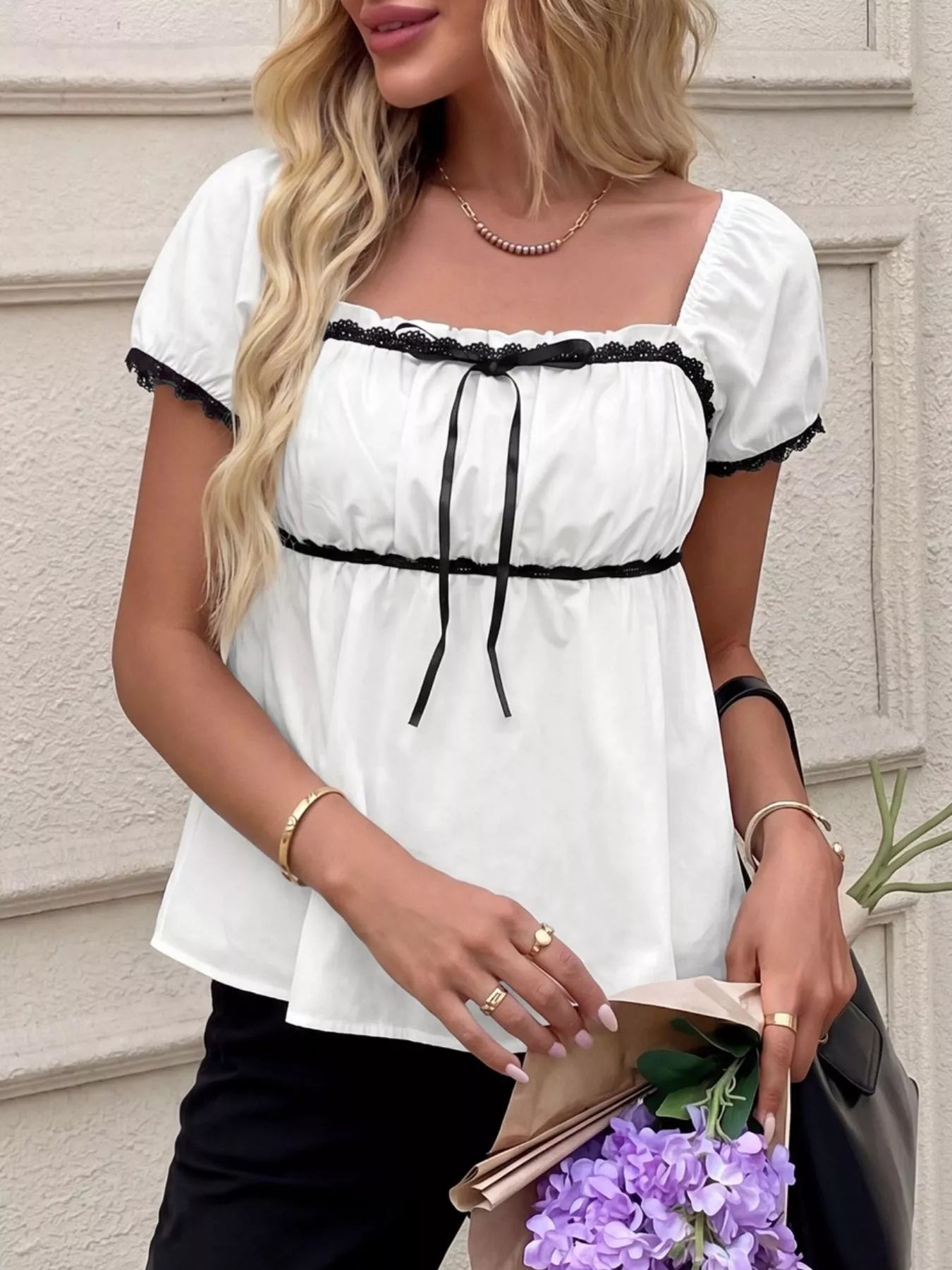 White short sleeve blouse with black lace trim, bowknot neckline and tie accents