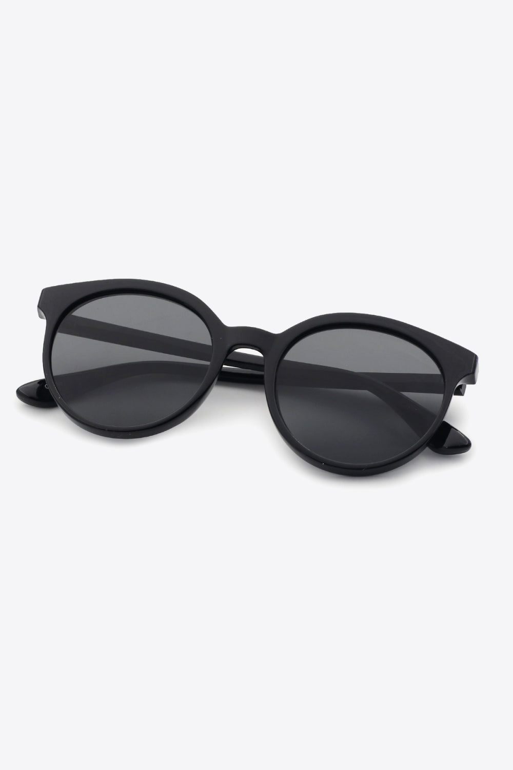 Black round sunglasses with dark lenses and full frame, angled view