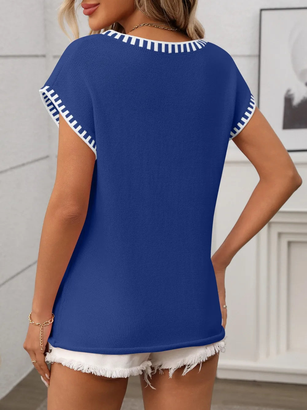 Royal blue v-neck short sleeve knit top with white contrast trim, back view