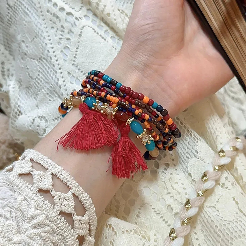 Multicolor bead tassel bracelet with red tassels and small turquoise bead charms
