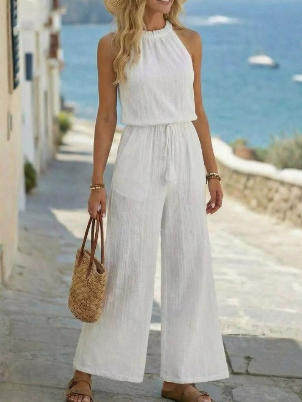 White halter sleeveless jumpsuit, smocked bodice, wide-leg pants, tassel ties