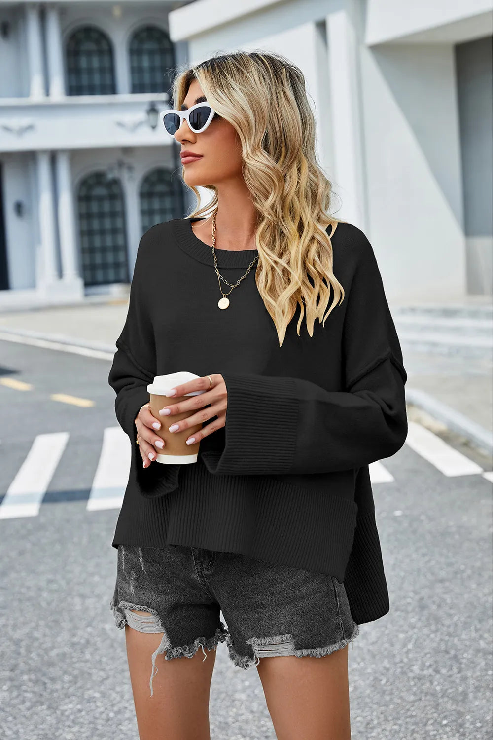 Black high-low slit sweater with round neck and long sleeves; ribbed trim details
