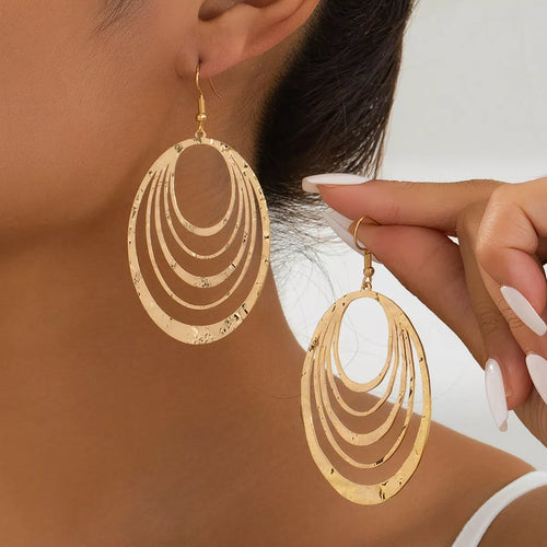 Gold-plated layered hoop earrings with oval shape and stacked concentric ridges