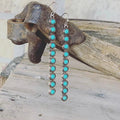 Long bar earrings with turquoise round stones in silver-tone settings, dangling from hooks