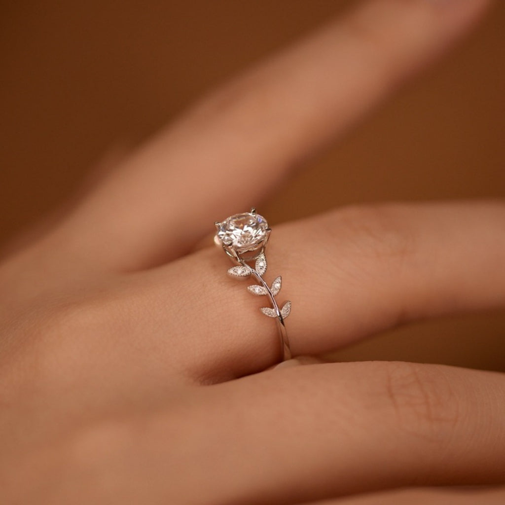 Close-up moissanite leaf ring: round center stone with small leaf links