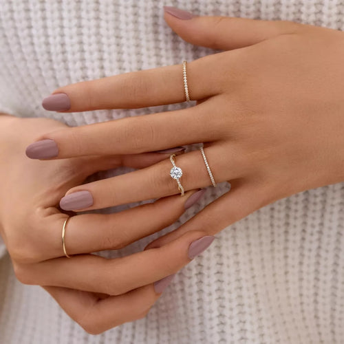 Gold-tone zircon ring on hand: round center stone with sparkling pavé band