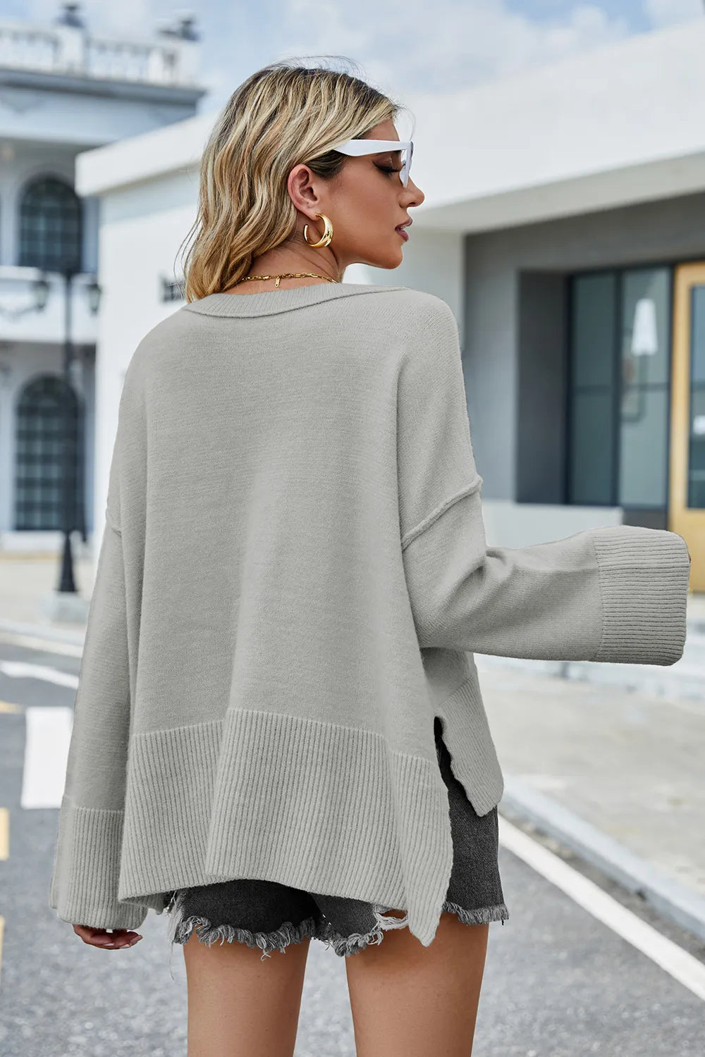 Back view: high-low slit sweater, light gray long sleeves with ribbed hem
