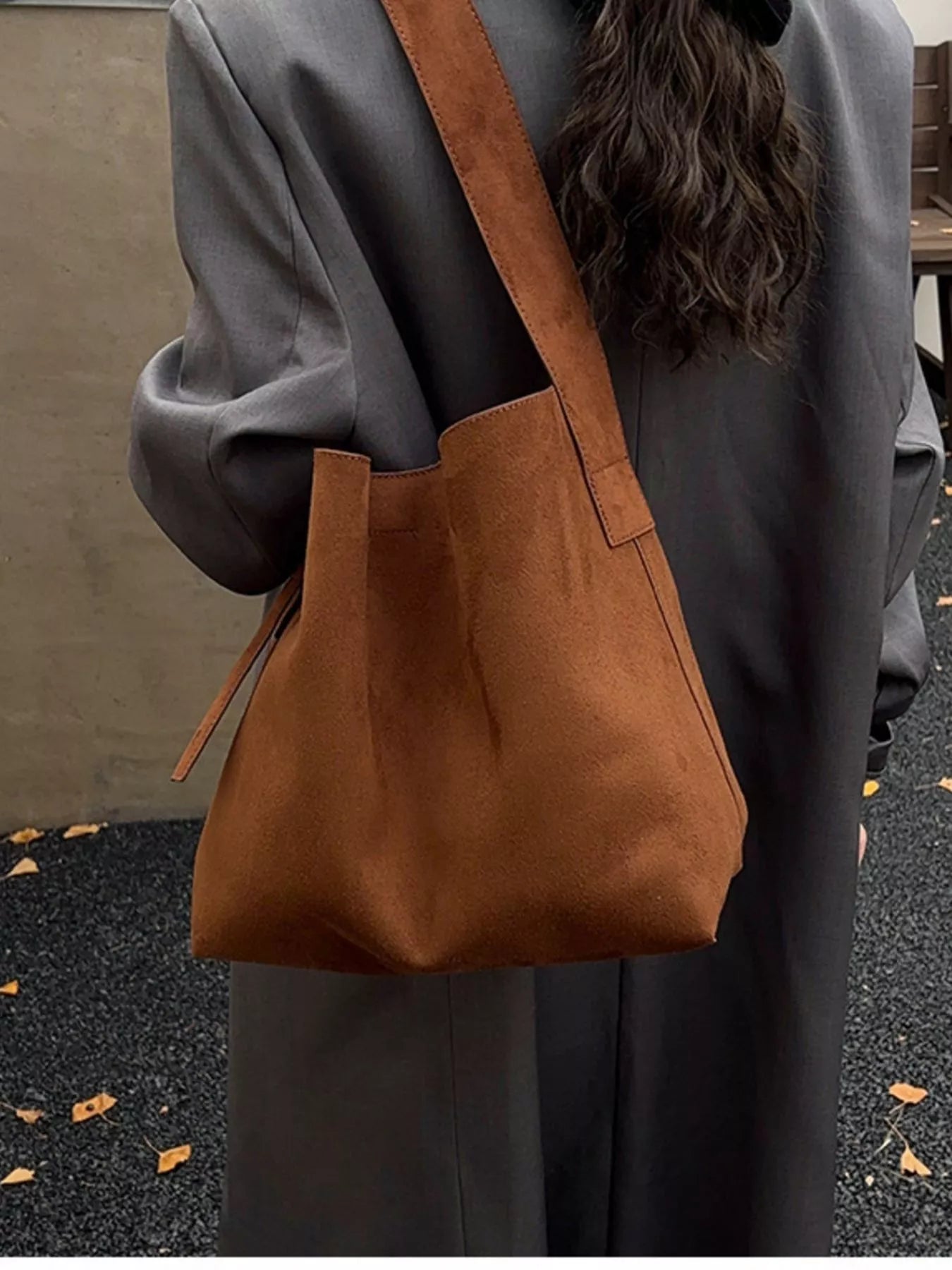 Brown tote bag with long adjustable strap and small tie tab on side