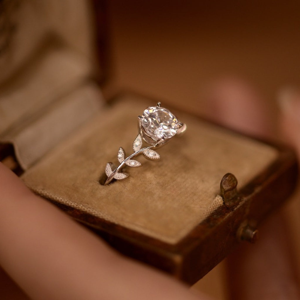 Moissanite leaf ring angled view: round center stone with raised leaf band