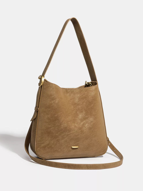 Brown faux leather shoulder bag with top handle and adjustable crossbody strap