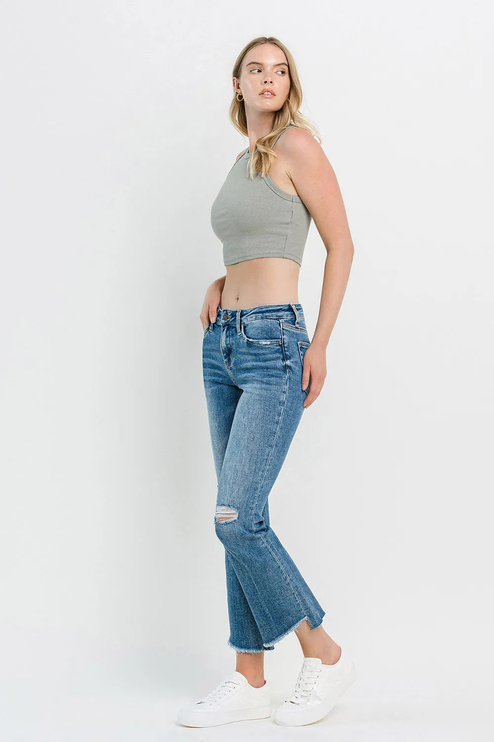 Medium-blue mid-rise flare jeans with distressed thighs and classic five-pocket design
