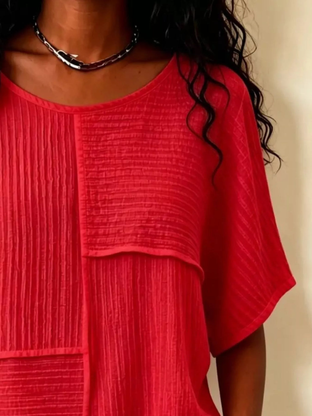 Red textured round-neck half-sleeve blouse close-up of vertical seam and yoke