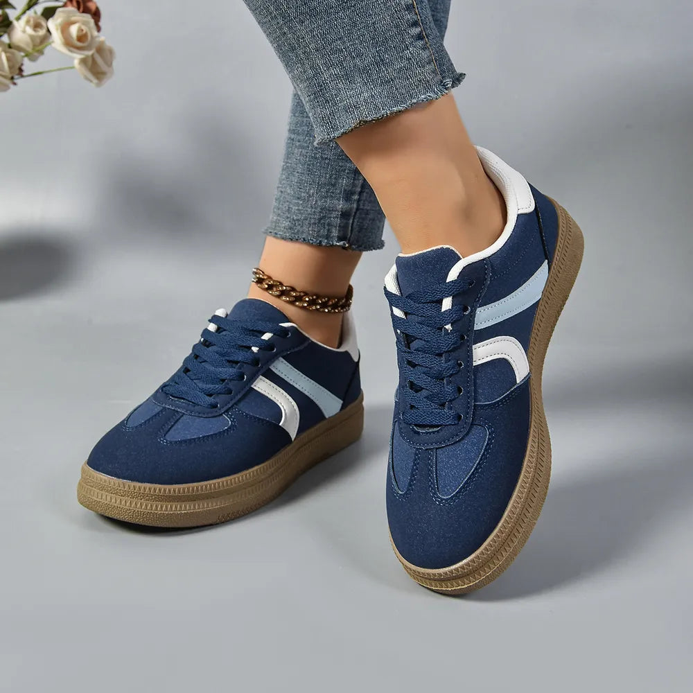 Navy platform sneakers with white accents, lace-up front and brown sole