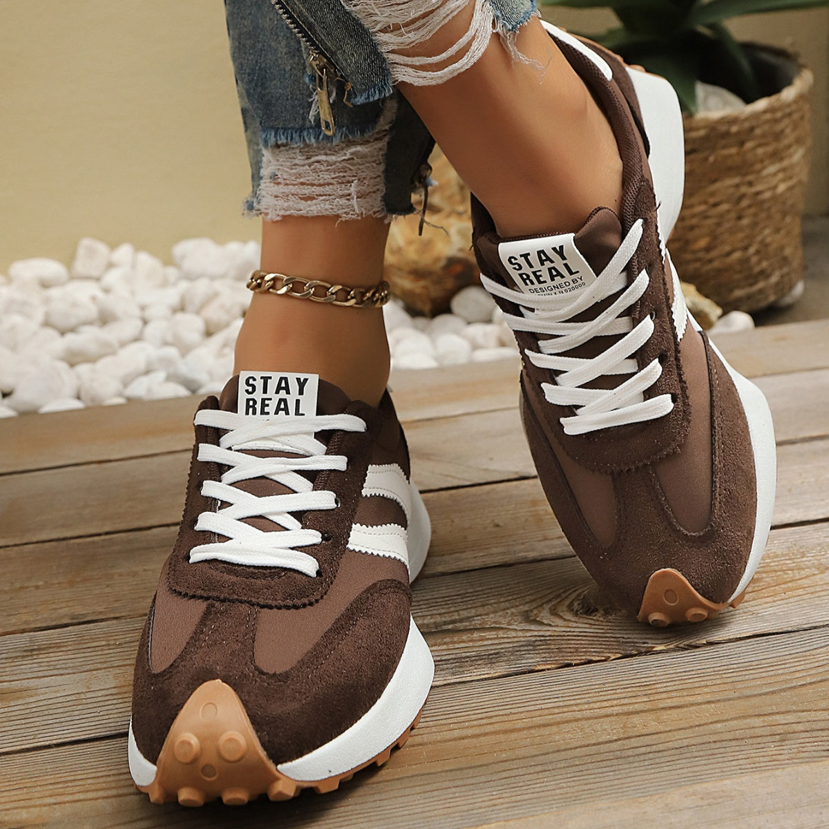 Brown lace-up sneakers with round toe, white stripes, and textured gum rubber sole