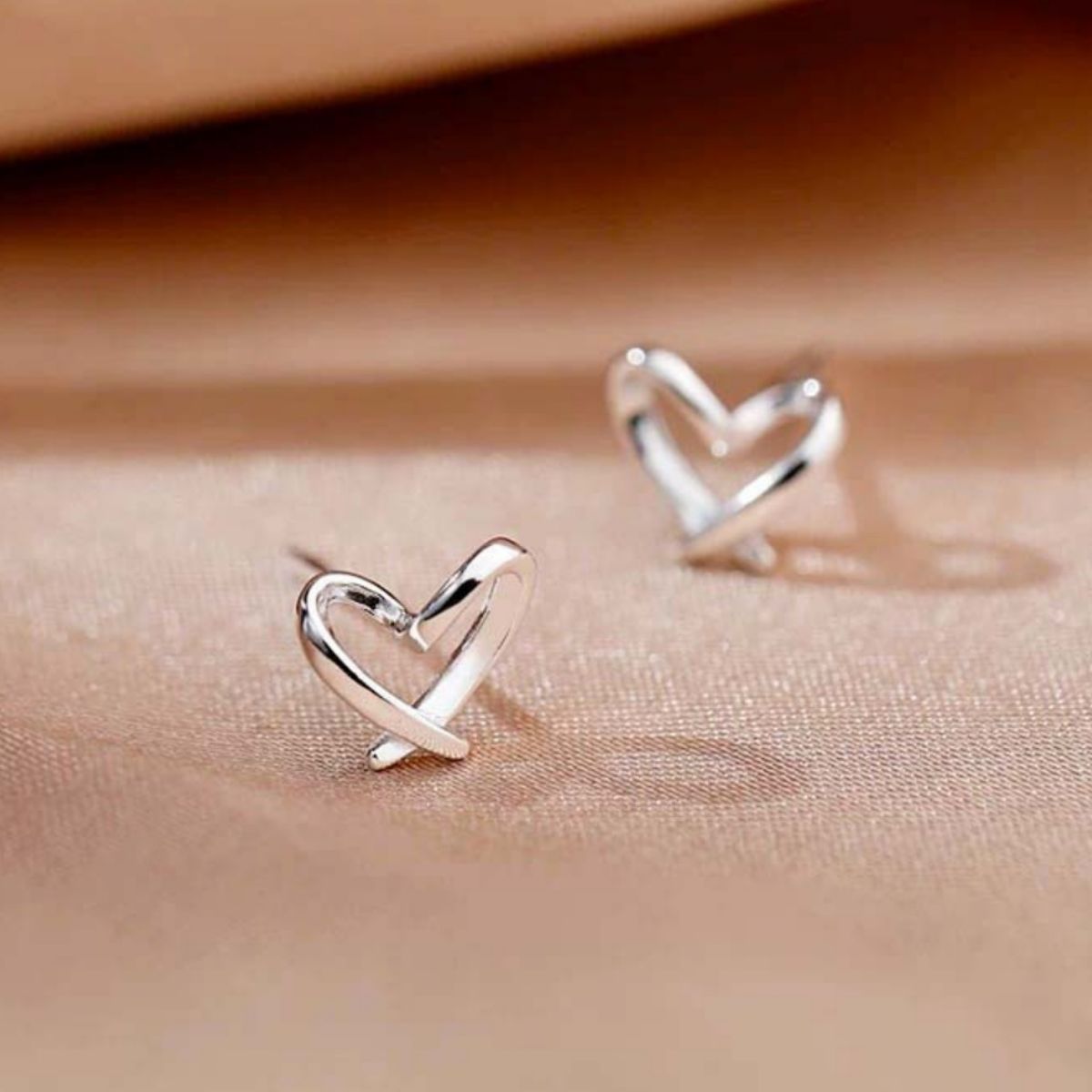 Silver heart-shaped stud earrings with glossy heart outline