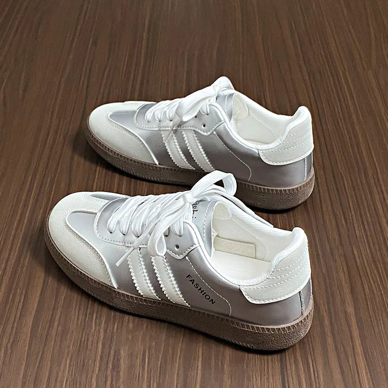 White lace-up sneakers with three side stripes and cushioned sole