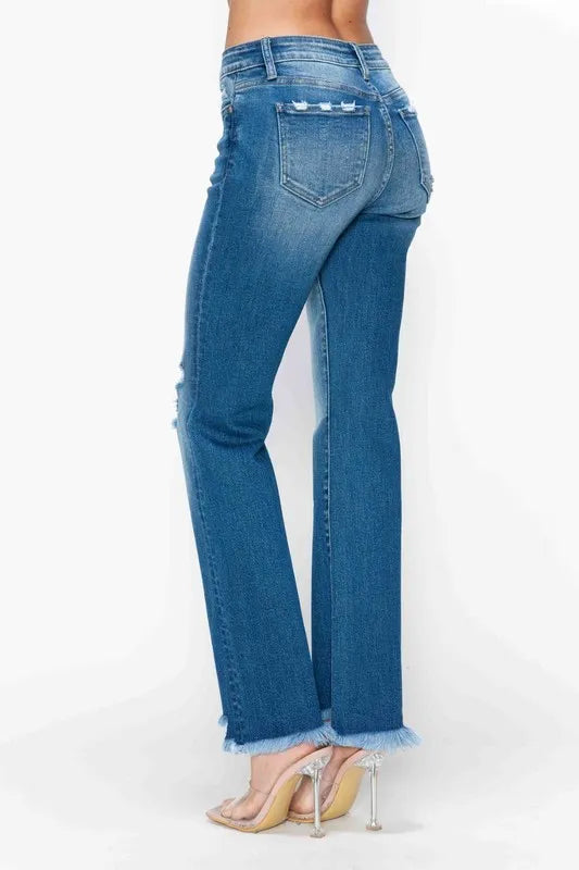 Back view of medium-wash straight jeans with distressed fading and frayed raw hem