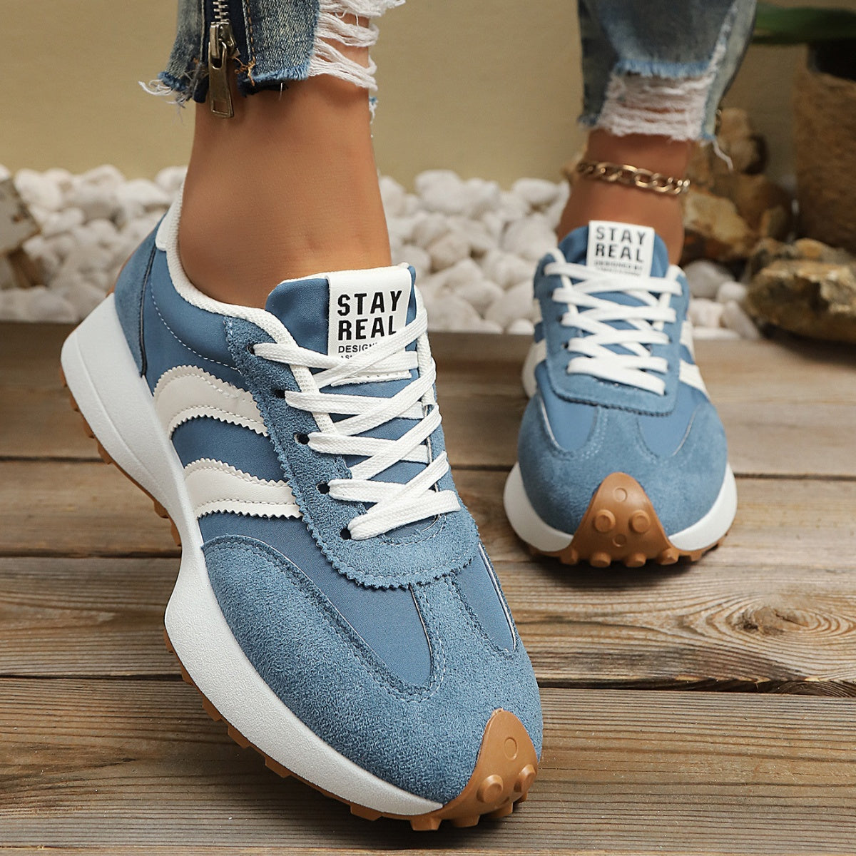 Sky blue lace-up sneakers with round toe, white stripes, and gum rubber sole