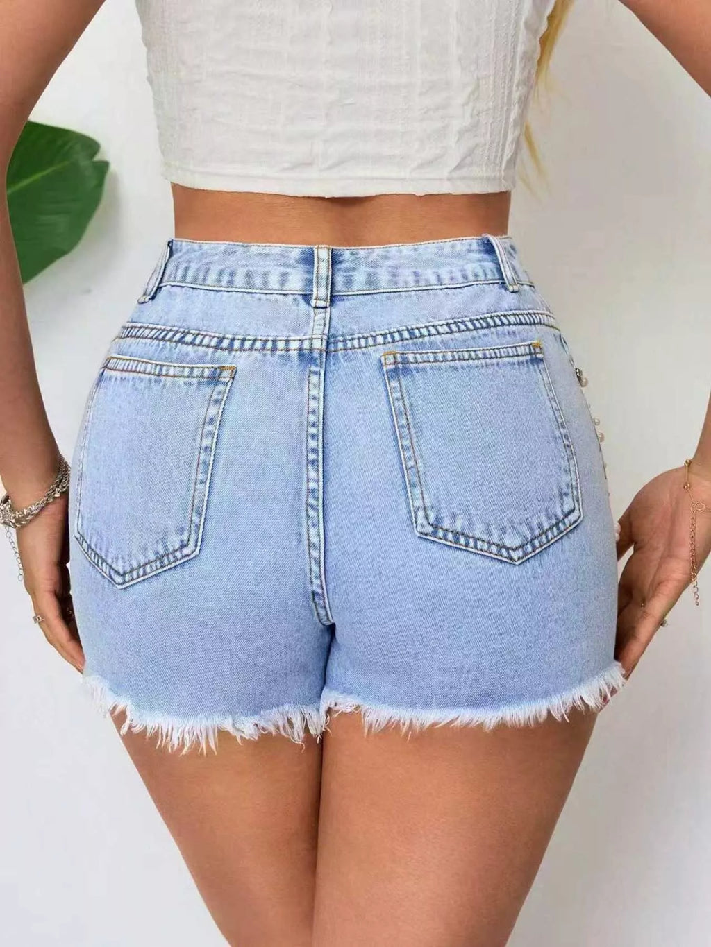Light blue denim shorts with front patch pockets and raw frayed hem