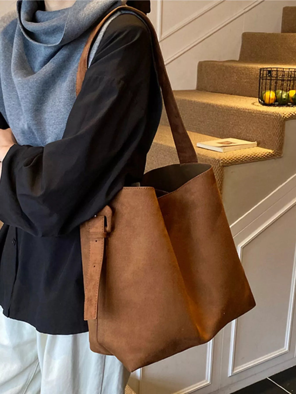 Brown adjustable strap tote bag with buckle detail and wide open top