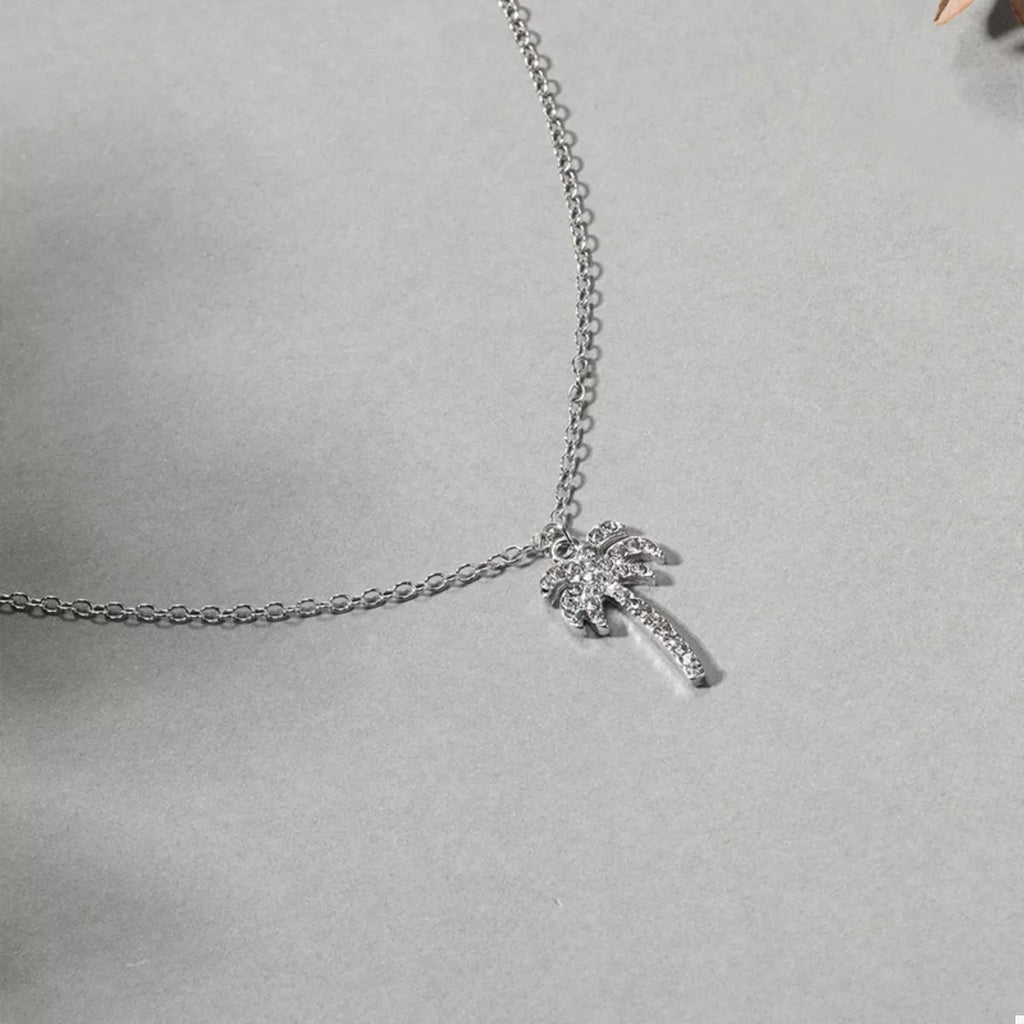 Close-up silver palm tree pendant with sparkle detailing on chain links