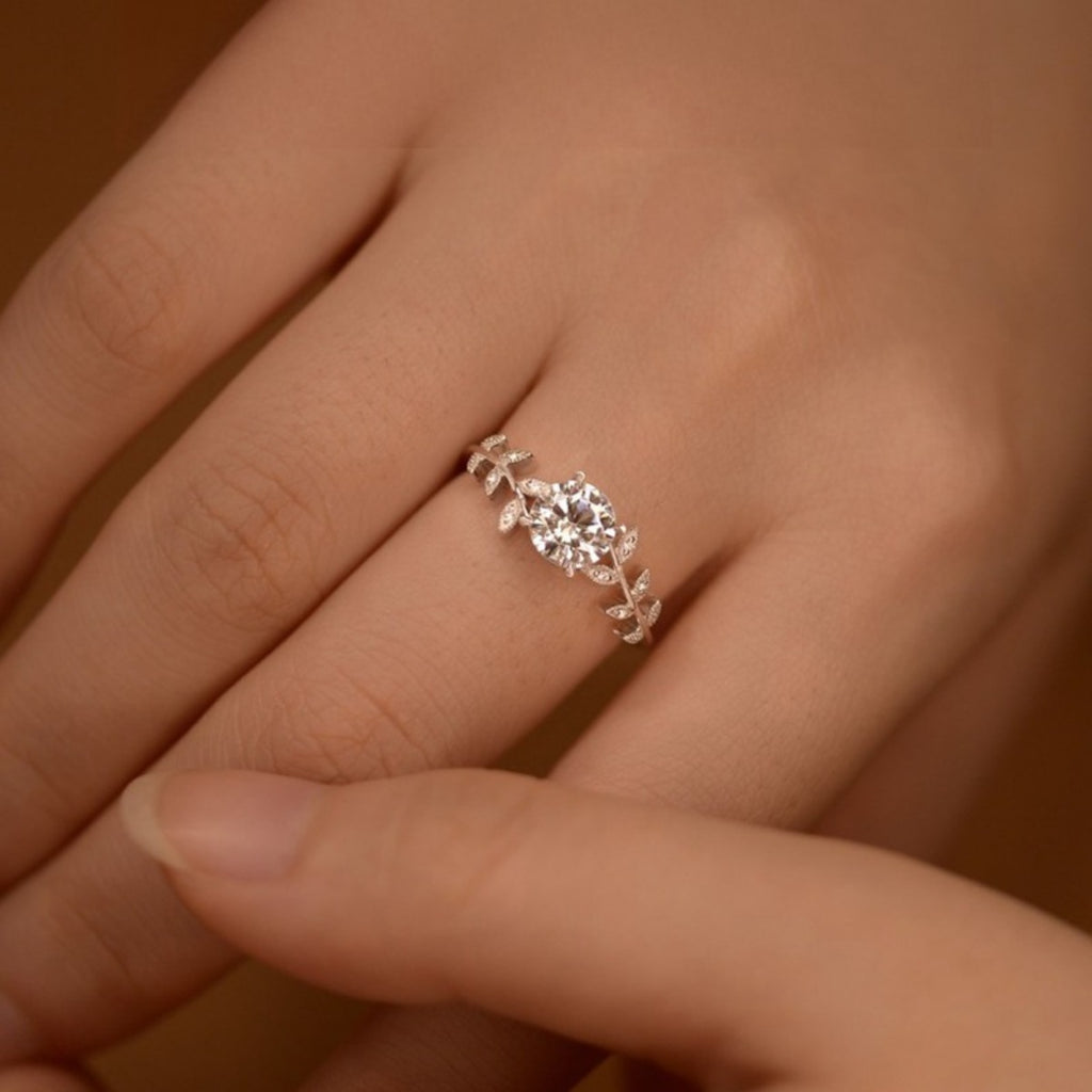 Moissanite leaf ring on hand, round center stone with pavé leaf details
