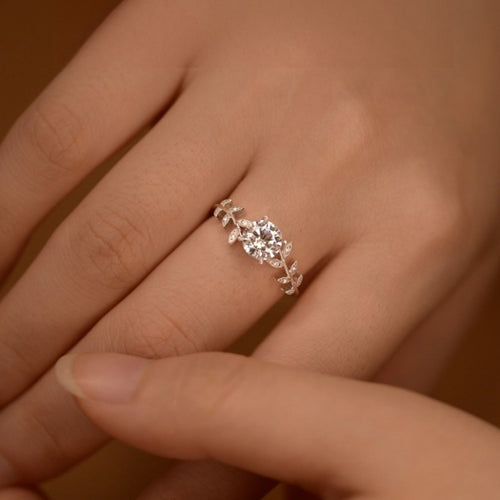 Moissanite leaf ring on hand, round center stone with pavé leaf details