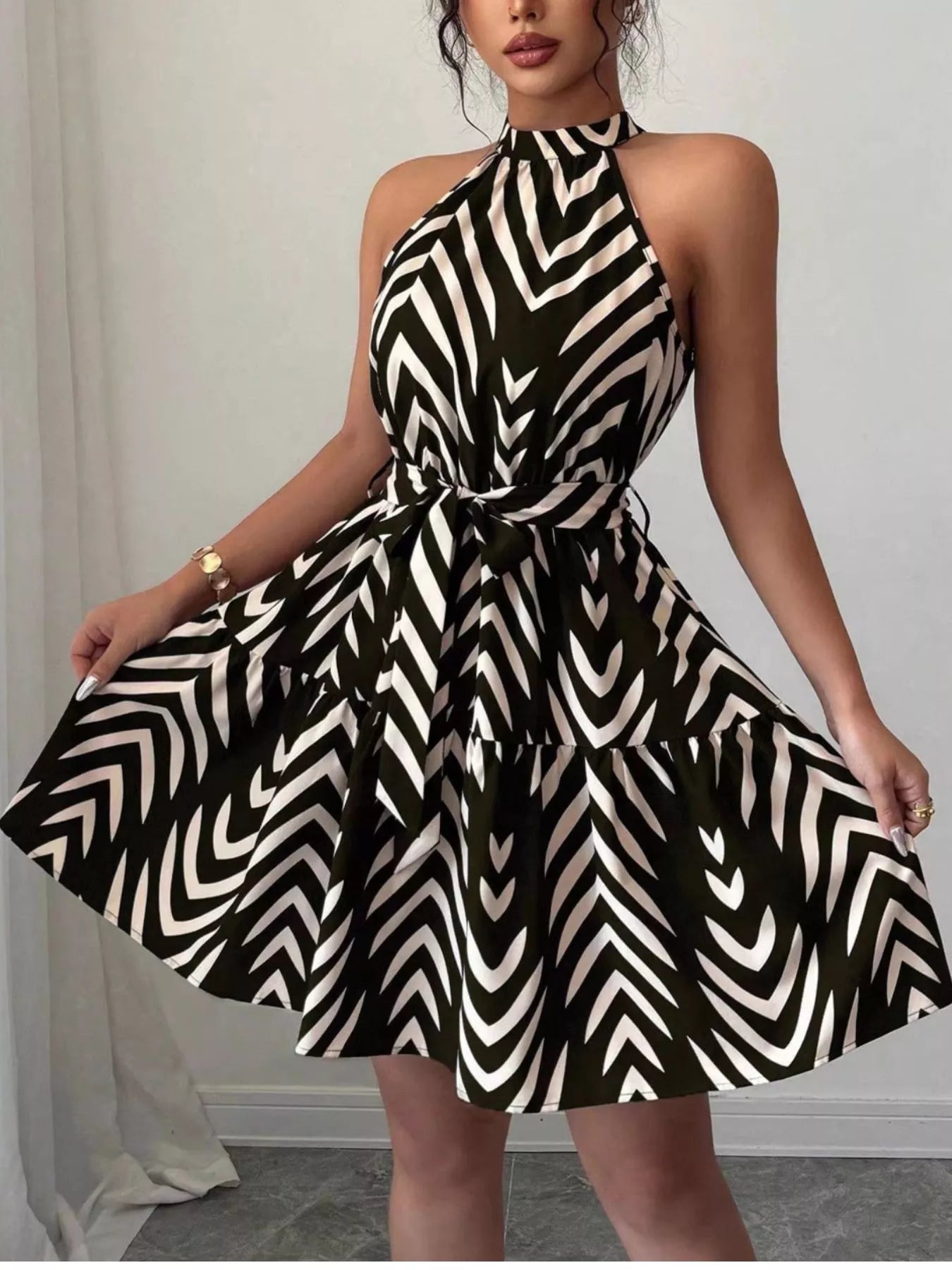 Black zebra-print halter dress with tie waist, wide ruffle hem and swingy skirt