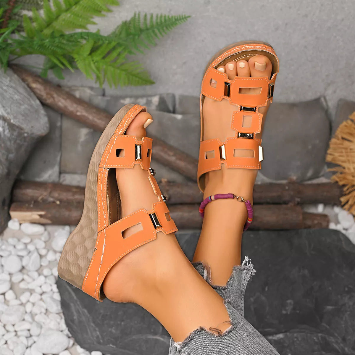 Orange open-toe wedge sandal with cutout straps and buckle closures, tan lining.