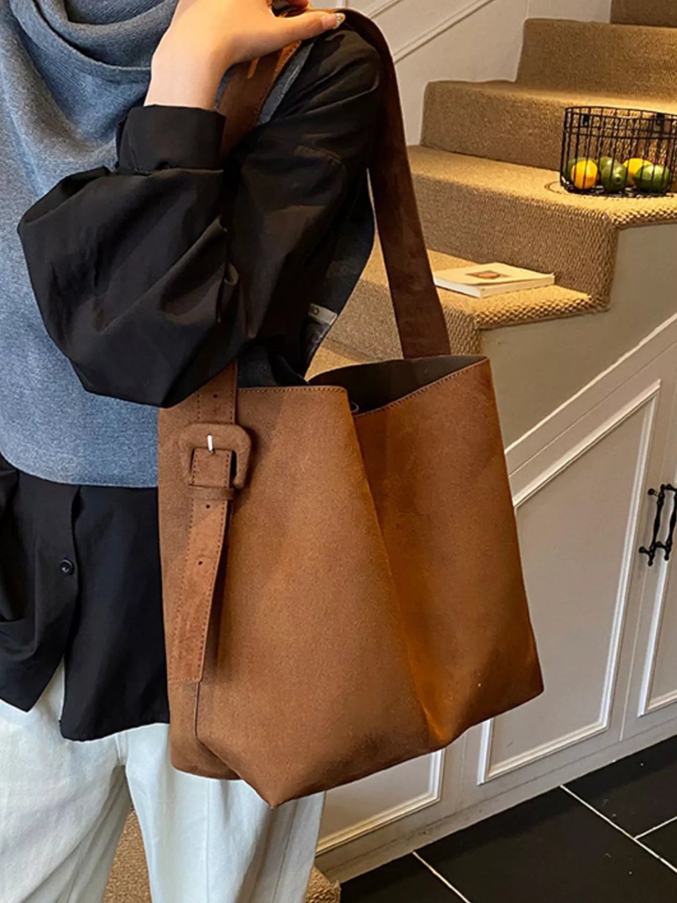 Brown adjustable strap tote bag with buckle and structured top edges