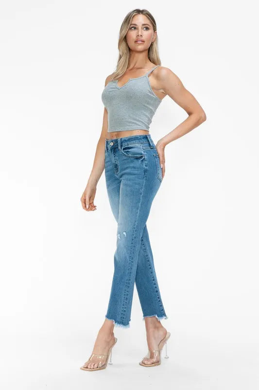 Front view of medium-wash mid-rise jeans with raw frayed hem and distressed detailing