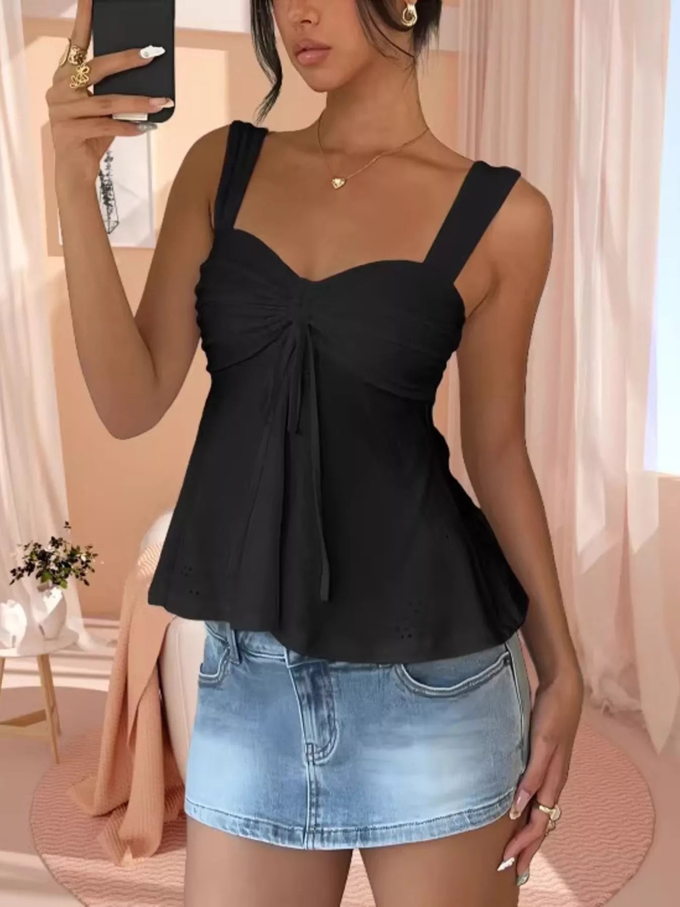 Black eyelet embroidered cami top with front drawstring bow and flared peplum hem
