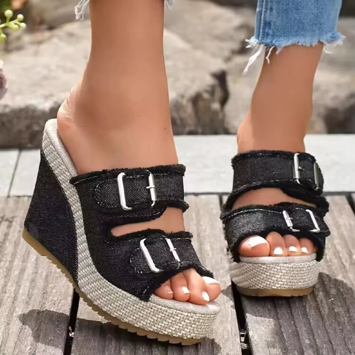 Black wedge sandals with open toe and two buckle straps on textured sole