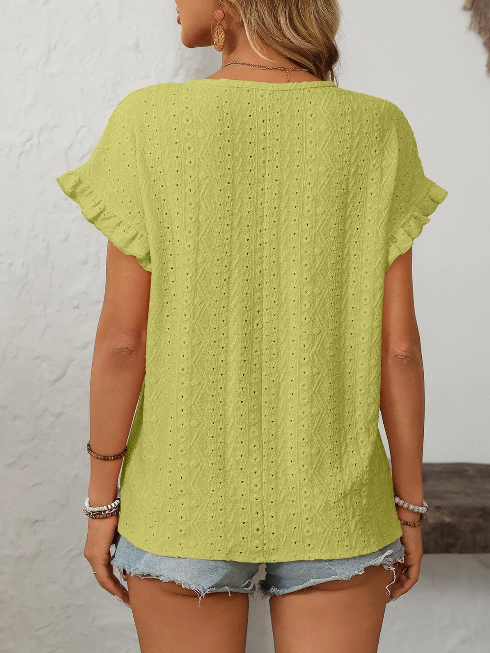 Lime green eyelet round-neck short-sleeve top, back view with flutter sleeves and textured fabric.