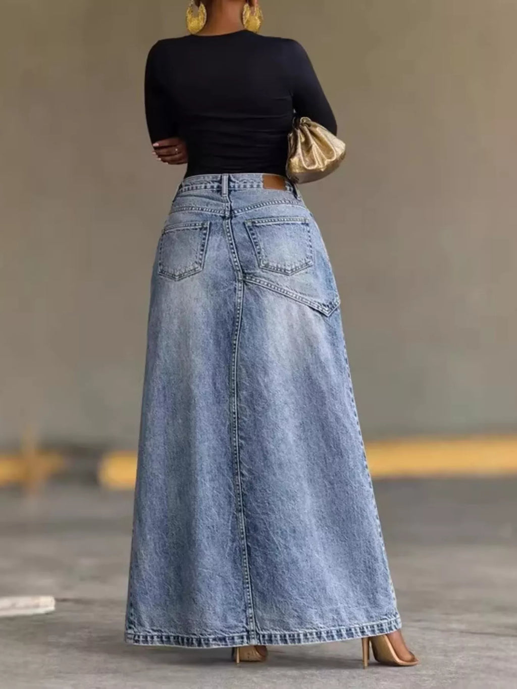 Blue high-waisted denim maxi skirt with five-pocket styling and button waistband