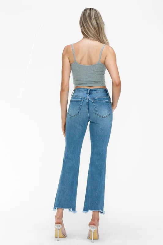 Back view of medium-wash mid-rise jeans with raw frayed hem and distressed wash