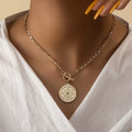 Gold chain link necklace with vintage coin pendant and bow clasp at center