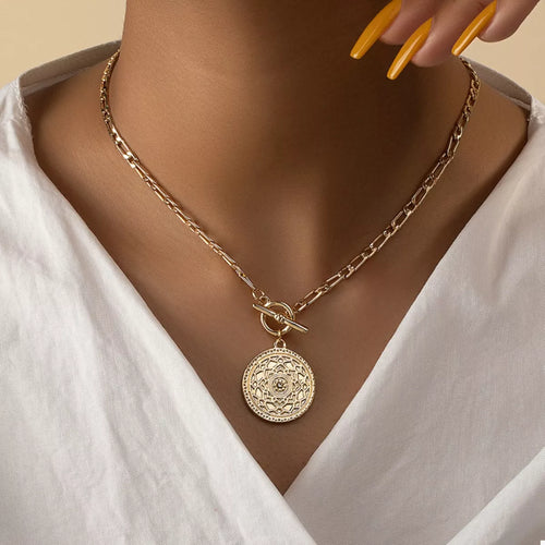 Gold chain link necklace with vintage coin pendant and bow clasp at center