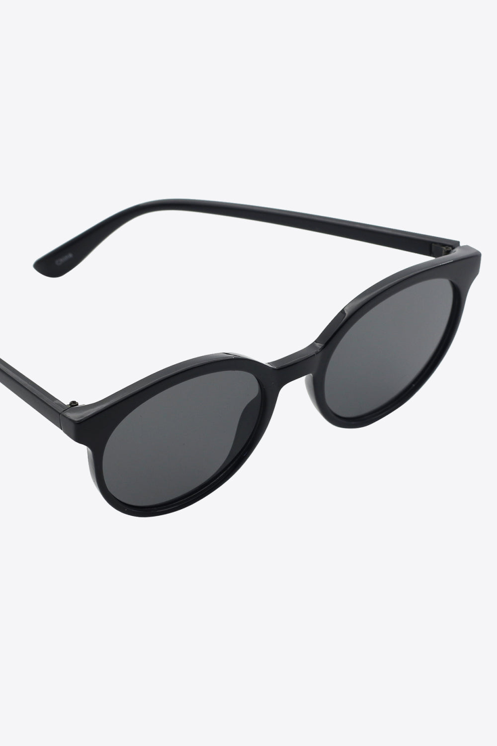 Black round full-rim sunglasses, side view with dark lenses and curved temples
