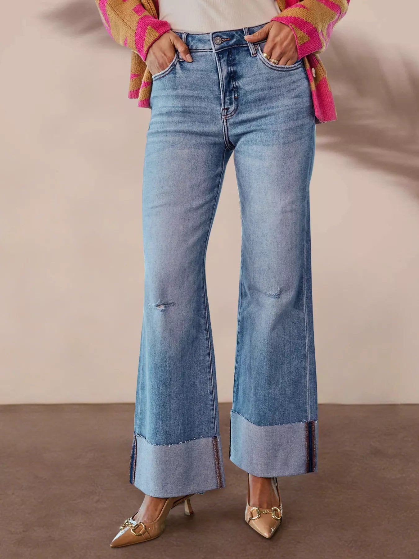 Light blue high-waisted flare jeans with distressed details and wide cuff hem